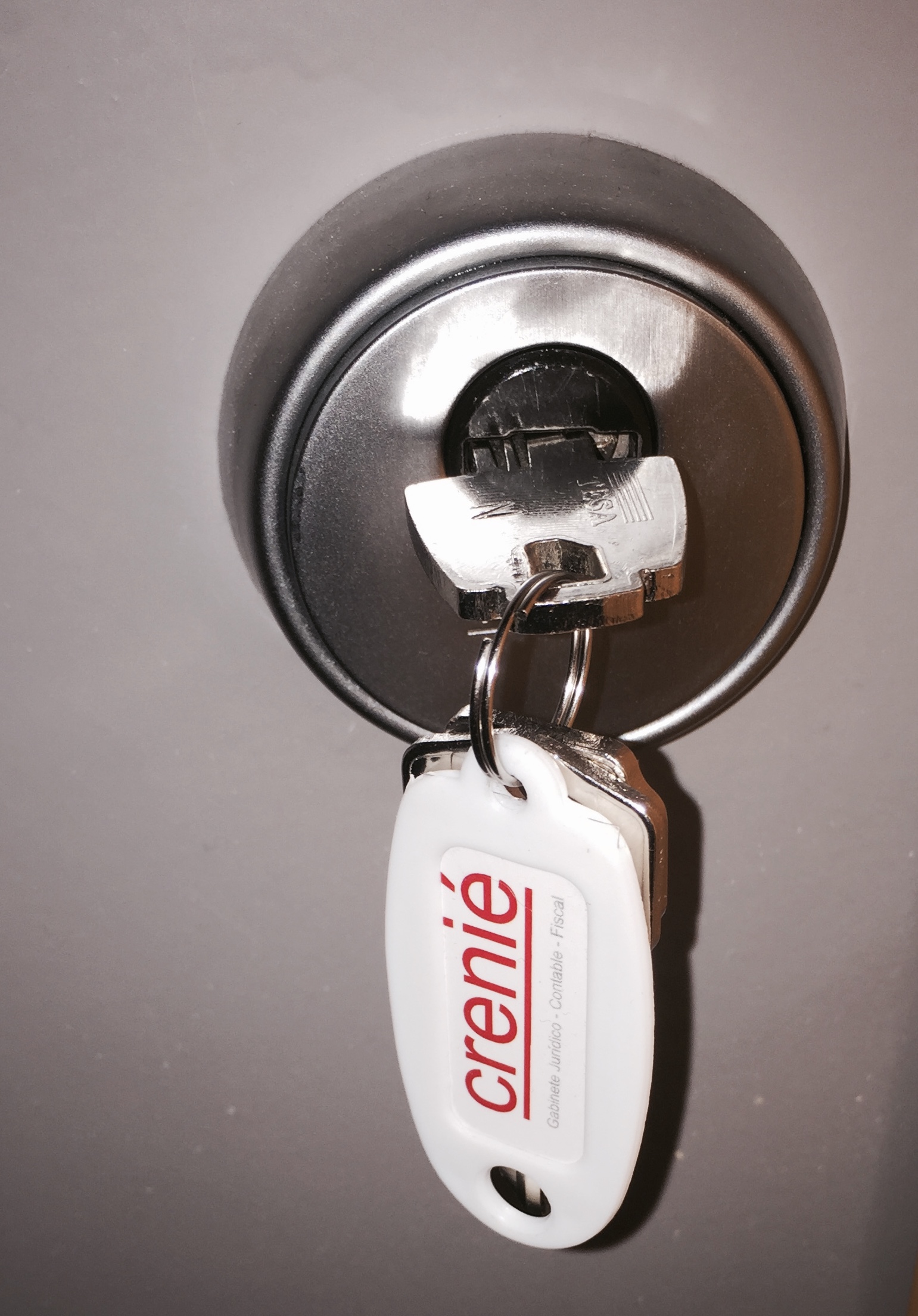 Detalle de las llaves en la puerta de entrada a las oficinas de crenie